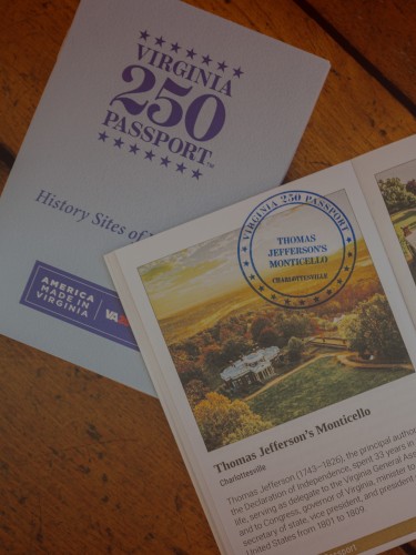 3 VA 250 Passport booklets spread out on a parquet floor, with the center one open to a description of Monticello