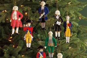 Embroidered cloth ornaments made to look like historic figures hang on a Christmas tree