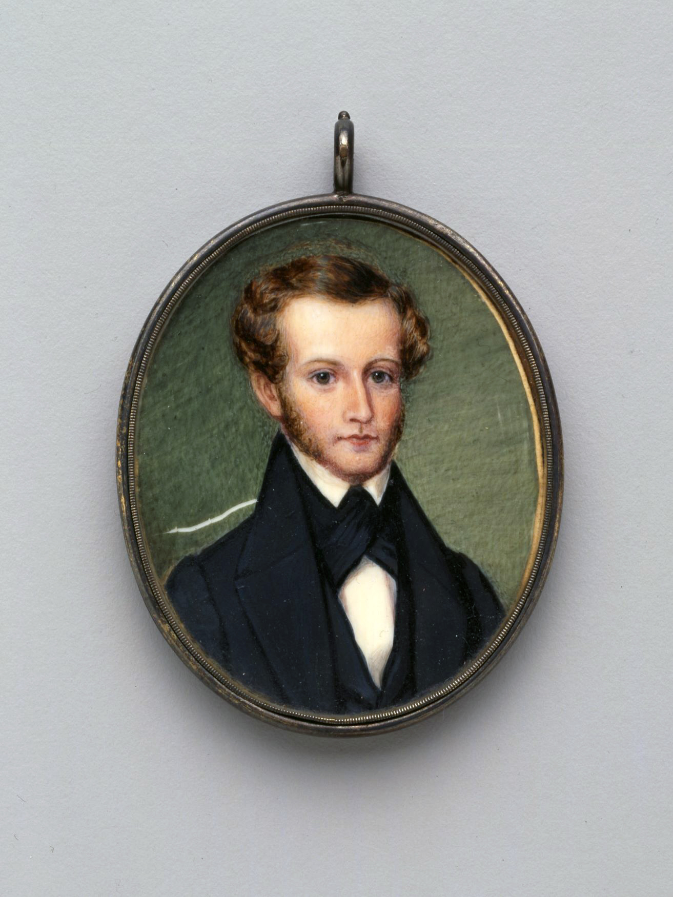 Oval-shaped bust-length portrait of Meriwether Lewis Randolph facing the viewer with body angled towards the proper left, encased in a silver frame. He wears a blue suit and waistcoat with a white collared shirt. He has long sideburns and ear-length curled hair. 