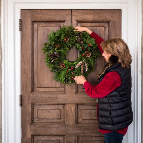 A Monticello staff member hangs a holiday wreath made of all-natural greenery